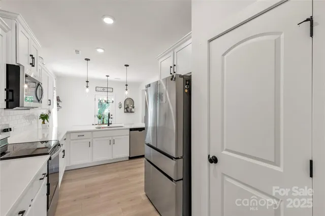 a kitchen with stainless steel appliances a refrigerator sink and stove