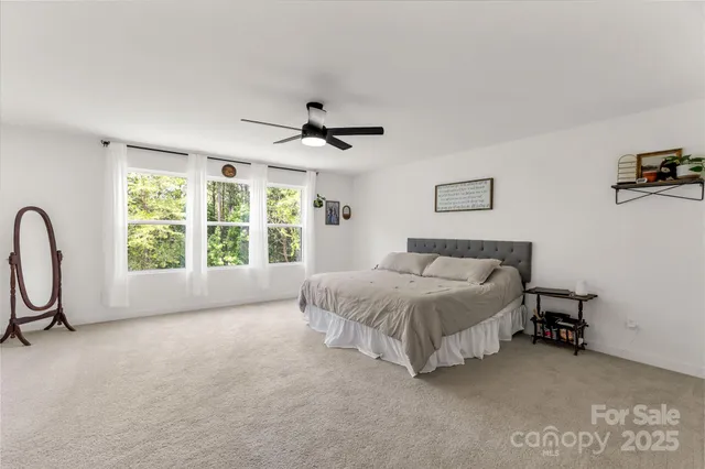 a spacious bedroom with a bed and a flat screen tv
