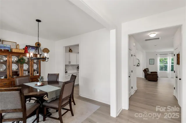 a view of a dining room and livingroom with furniture wooden floor a chandelier