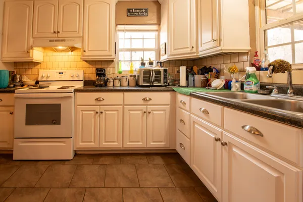 a kitchen with white cabinets and white appliances