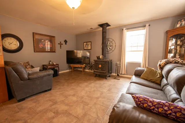 a living room with furniture a bed and a flat screen tv