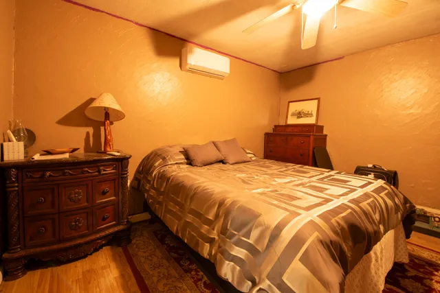 a bedroom with a bed and wooden floor