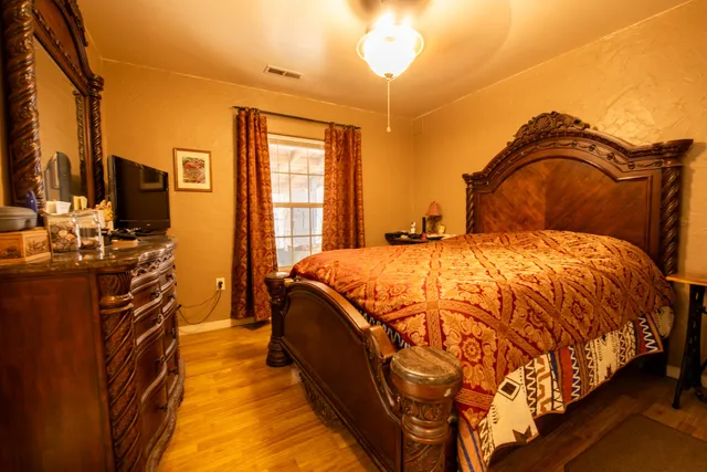 a spacious bedroom with a bed and a flat screen tv