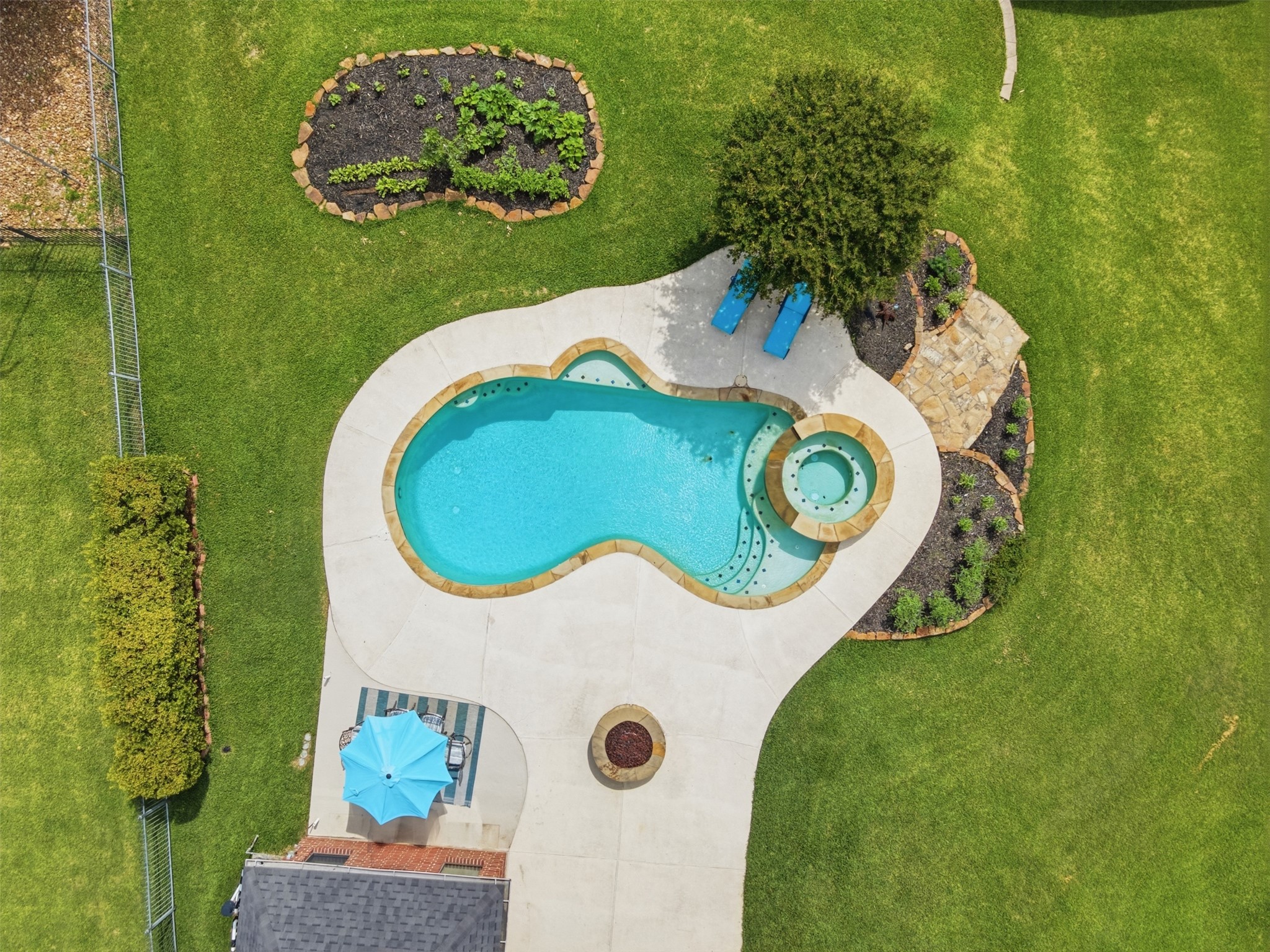 12710 Aries Loop Willis, TX 77318 - Photo 39 of 40 The property features a large lawn area, a swimming pool with an integrated spa, and a concrete patio