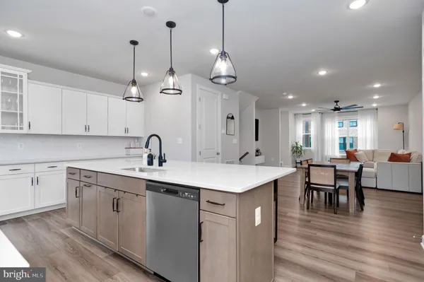 a kitchen with center island white cabinets sink and stainless steel appliances