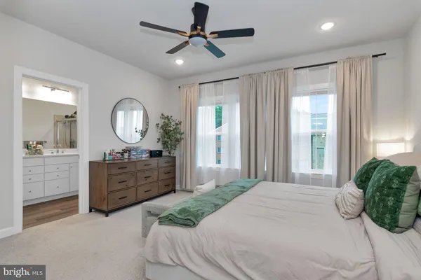 a bedroom with a large bed and a mirror on the dresser