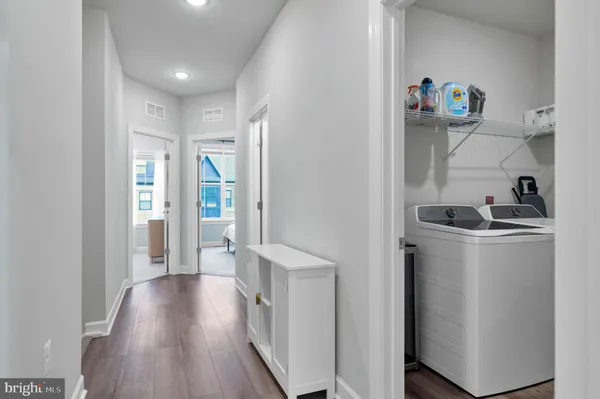 a hallway with wooden floor and cabinets