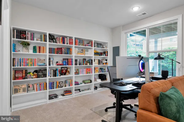 a living room with furniture and a book shelf