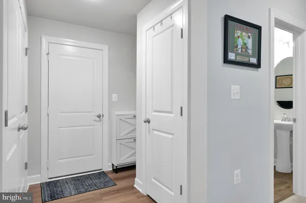 a view of a hallway with wooden floor and closet