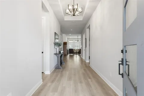 a view of a hallway with wooden floor and a living room
