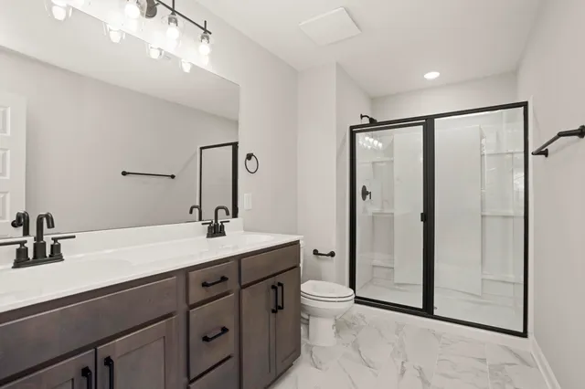 a bathroom with a sink a toilet and shower