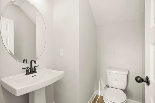 a bathroom with a toilet a sink and mirror