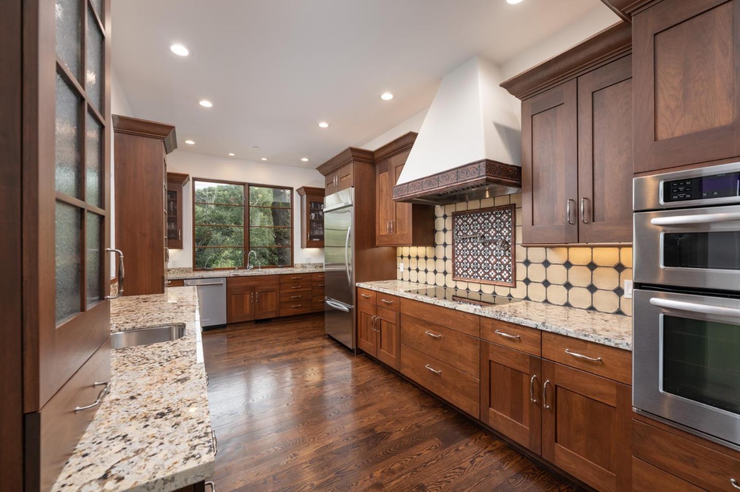 1036 Los Trancos Road Portola Valley, CA 94028 - Photo 5 of 33 a kitchen with stainless steel appliances kitchen island granite countertop a stove a sink and a refrigerator