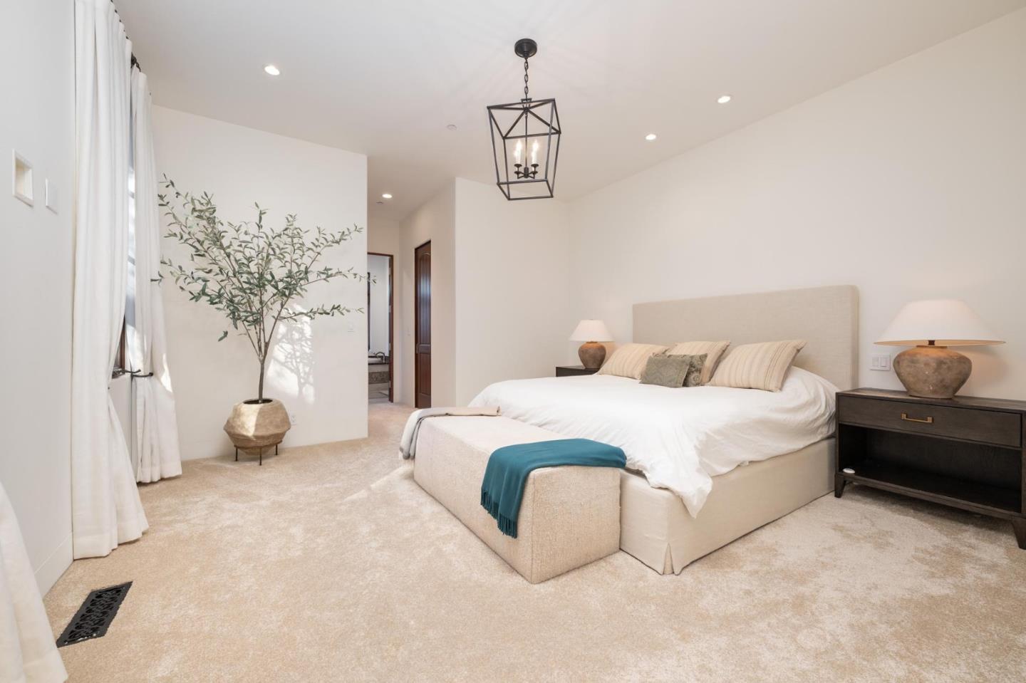 1036 Los Trancos Road Portola Valley, CA 94028 - Photo 10 of 33 a spacious bedroom with a bed and a chandelier