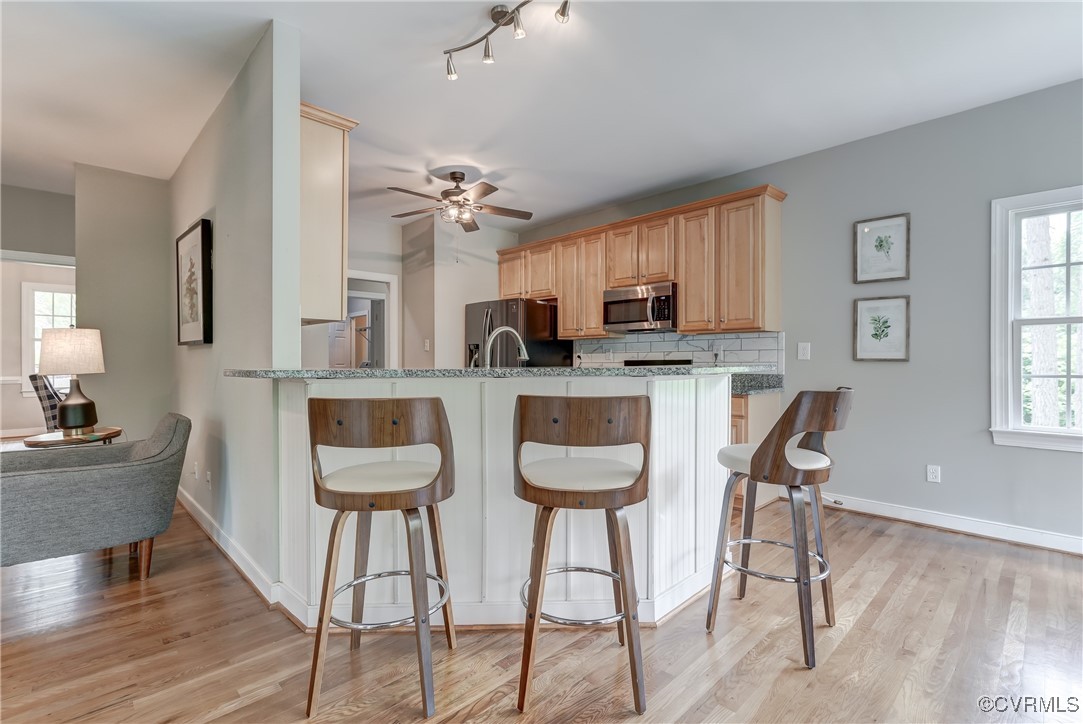5501 Pine Needles Terrace Providence Forge, VA 23140 - Photo 11 of 50 a kitchen with stainless steel appliances kitchen island granite countertop a dining table chairs and a refrigerator