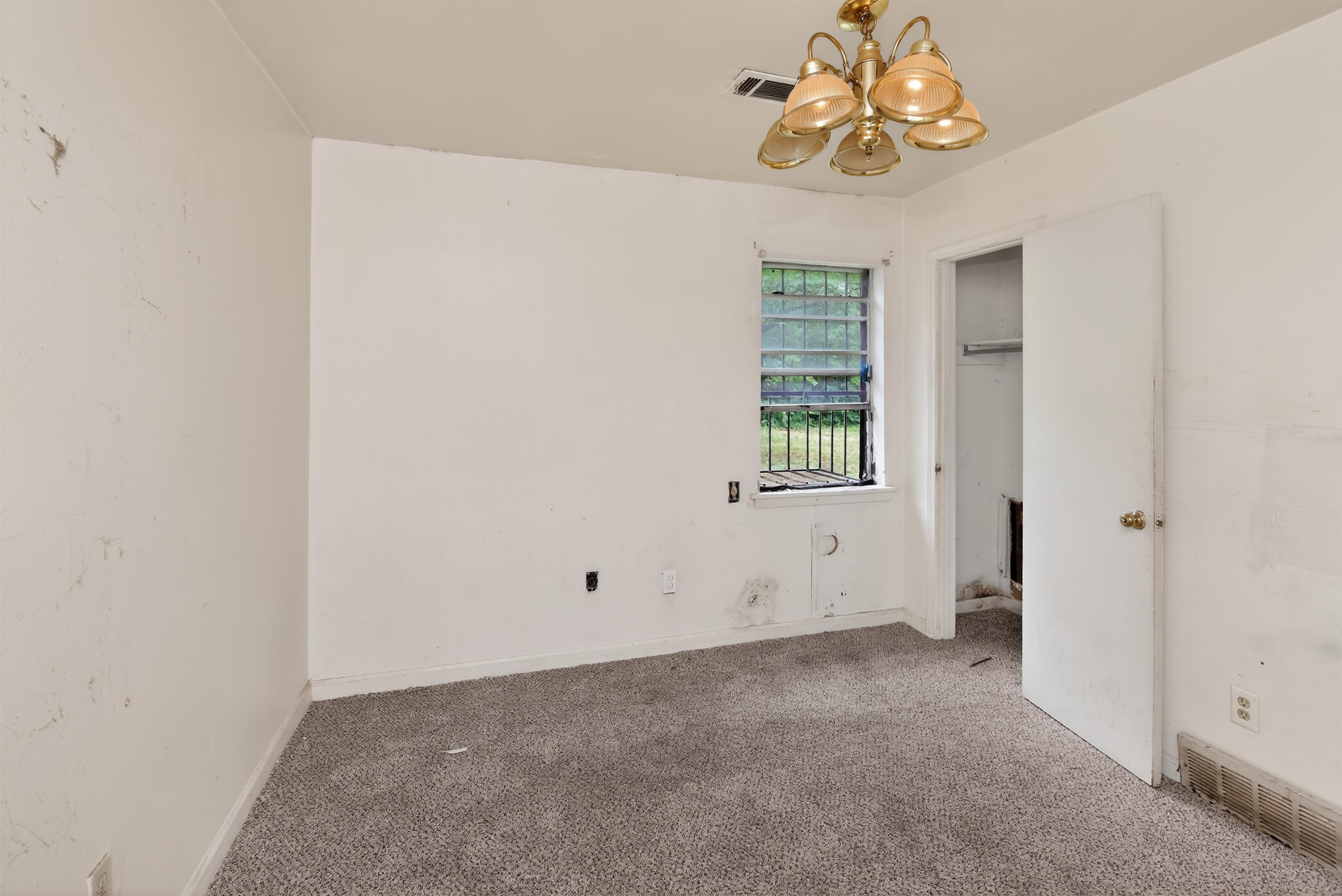 3451 Birdsong Ferry Road Memphis, TN 38118 - Photo 21 of 27 Carpeted room with a ceiling-mounted light fixture, window with security bars, and an open doorway