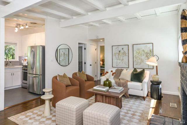 a living room with furniture a clock on wall and a window