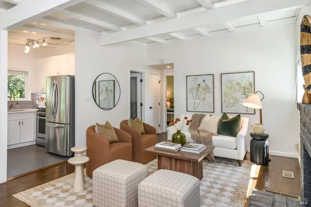 a living room with furniture a clock on wall and a window