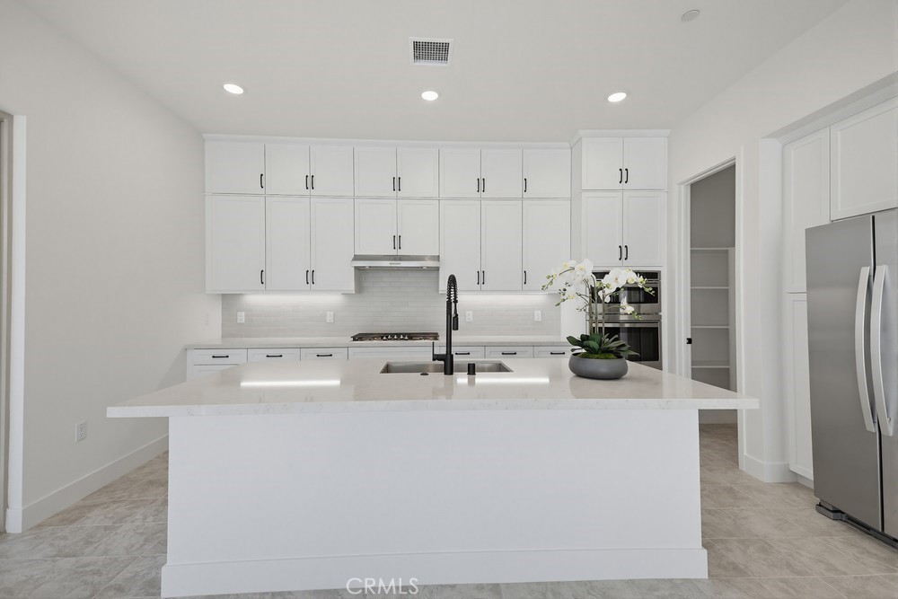 452 Botanica Rancho Mission Viejo, CA 92694 - Photo 20 of 53 a kitchen with stainless steel appliances a refrigerator a sink and white cabinets