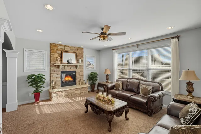 a living room with furniture a fireplace and a potted plant