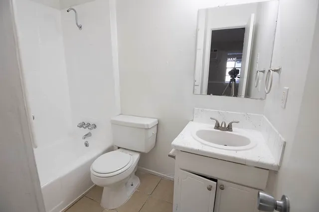 a bathroom with a toilet sink and mirror