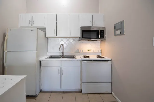 a kitchen with cabinets stainless steel appliances and sink