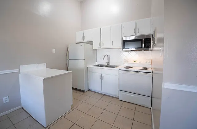 a utility room with cabinets washer and dryer