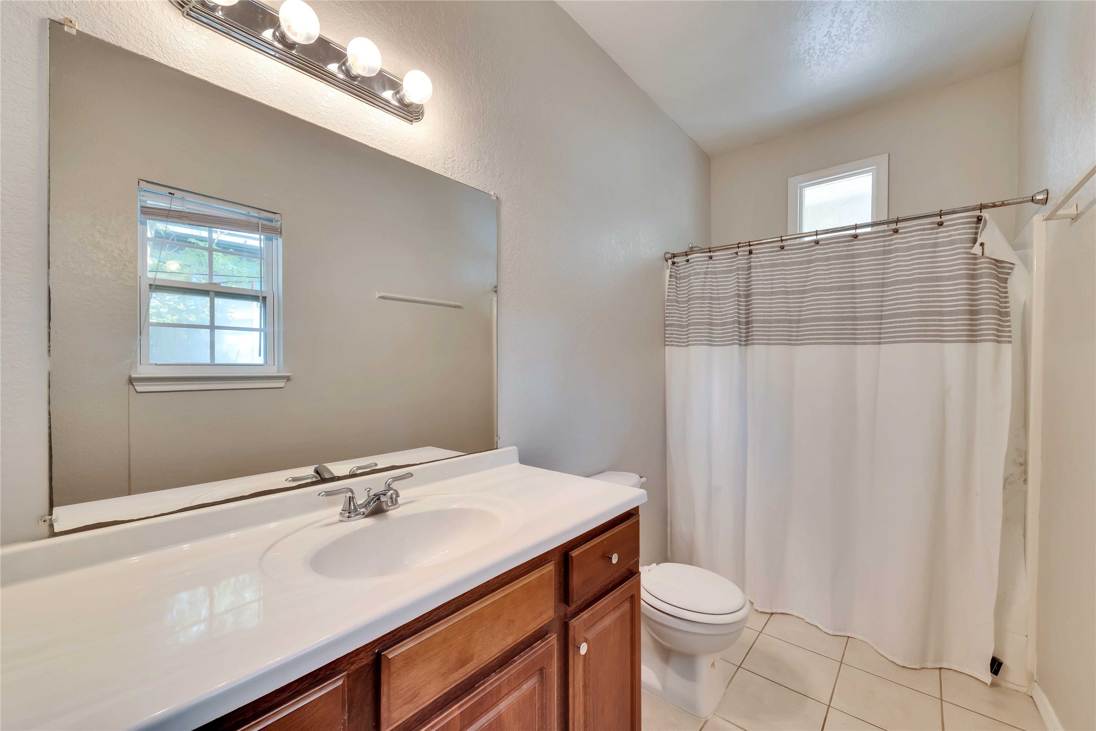 2201 East 18th Street, Unit B Austin, TX 78702 - Photo 12 of 25 A well-appointed bathroom features a single vanity, a spacious mirror, and a convenient shower.