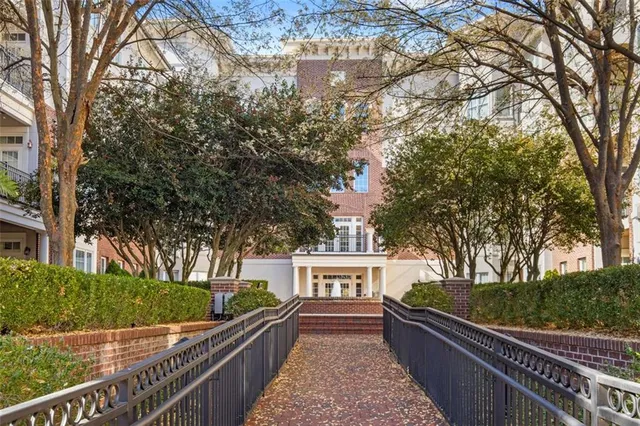 a front view of a brick building with a fountain in front of it