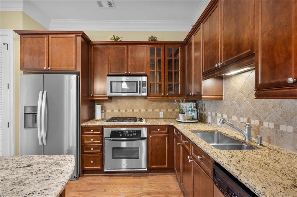 3635 East Paces Circle, Unit 1103 Atlanta, GA 30326 - Photo 15 of 37 a kitchen with stainless steel appliances granite countertop a sink stove and refrigerator