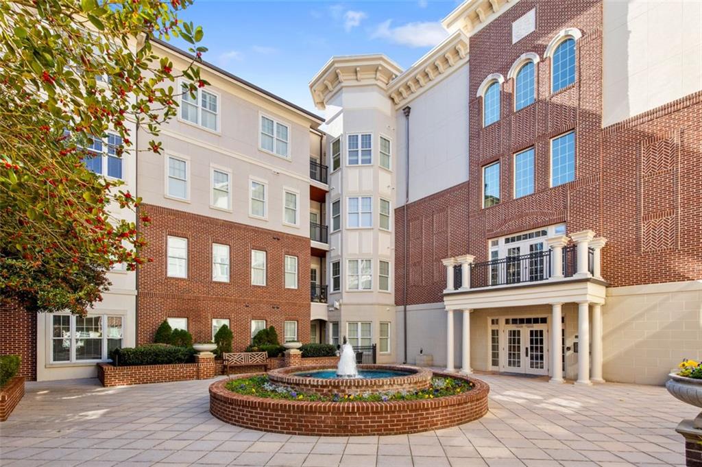 3635 East Paces Circle, Unit 1103 Atlanta, GA 30326 - Photo 2 of 37 a front view of a brick building with a fountain in front of it