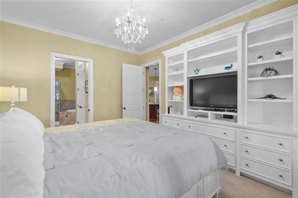 3635 East Paces Circle, Unit 1103 Atlanta, GA 30326 - Photo 21 of 37 a bedroom with a bed and a flat screen tv in it
