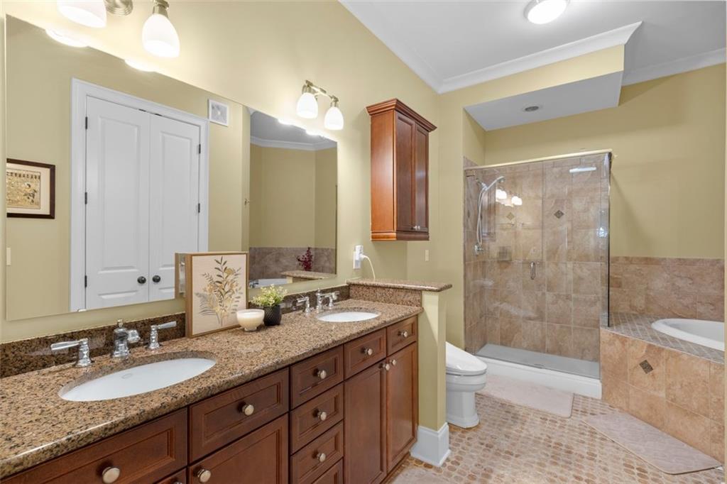 3635 East Paces Circle, Unit 1103 Atlanta, GA 30326 - Photo 22 of 37 a bathroom with a granite countertop double vanity sink toilet mirror and shower