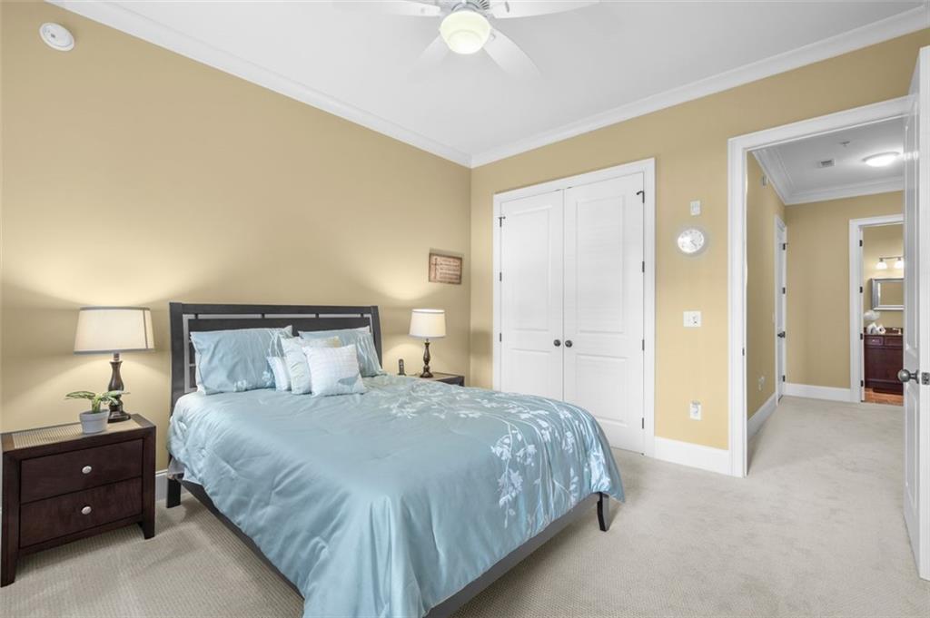 3635 East Paces Circle, Unit 1103 Atlanta, GA 30326 - Photo 28 of 37 a bedroom with a bed and a lamp