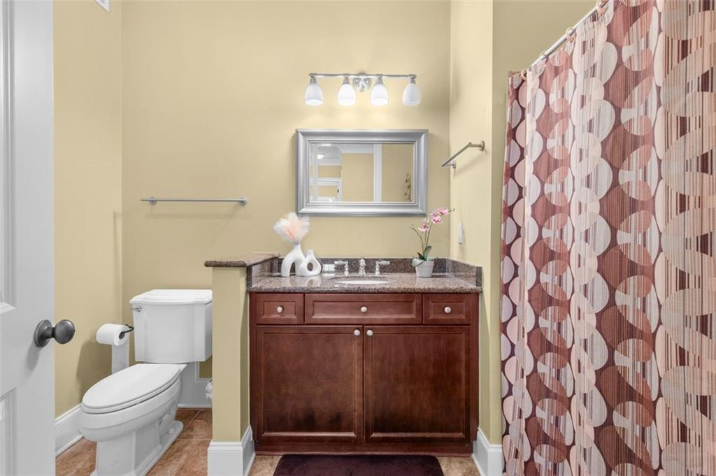 3635 East Paces Circle, Unit 1103 Atlanta, GA 30326 - Photo 29 of 37 a view of bathroom with a toilet and a mirror