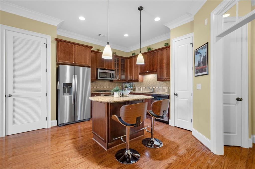 3635 East Paces Circle, Unit 1103 Atlanta, GA 30326 - Photo 3 of 37 a kitchen with stainless steel appliances granite countertop a refrigerator a stove a sink dishwasher and a refrigerator with wooden floor