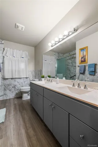 a bathroom with a granite countertop sink mirror and toilet