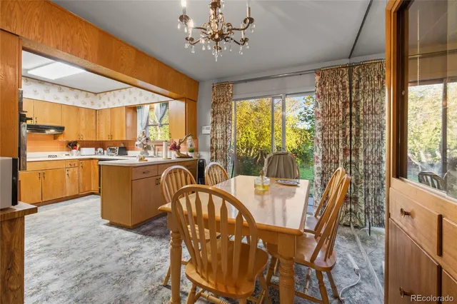 a dining room with furniture a chandelier and wooden floor