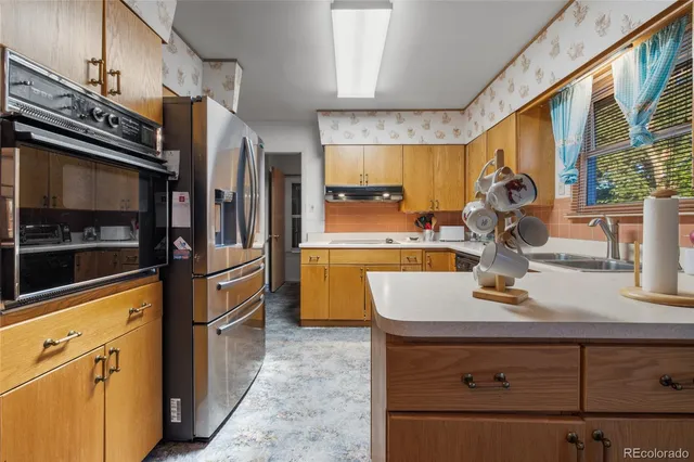 a kitchen with kitchen island a counter appliances a sink and cabinets