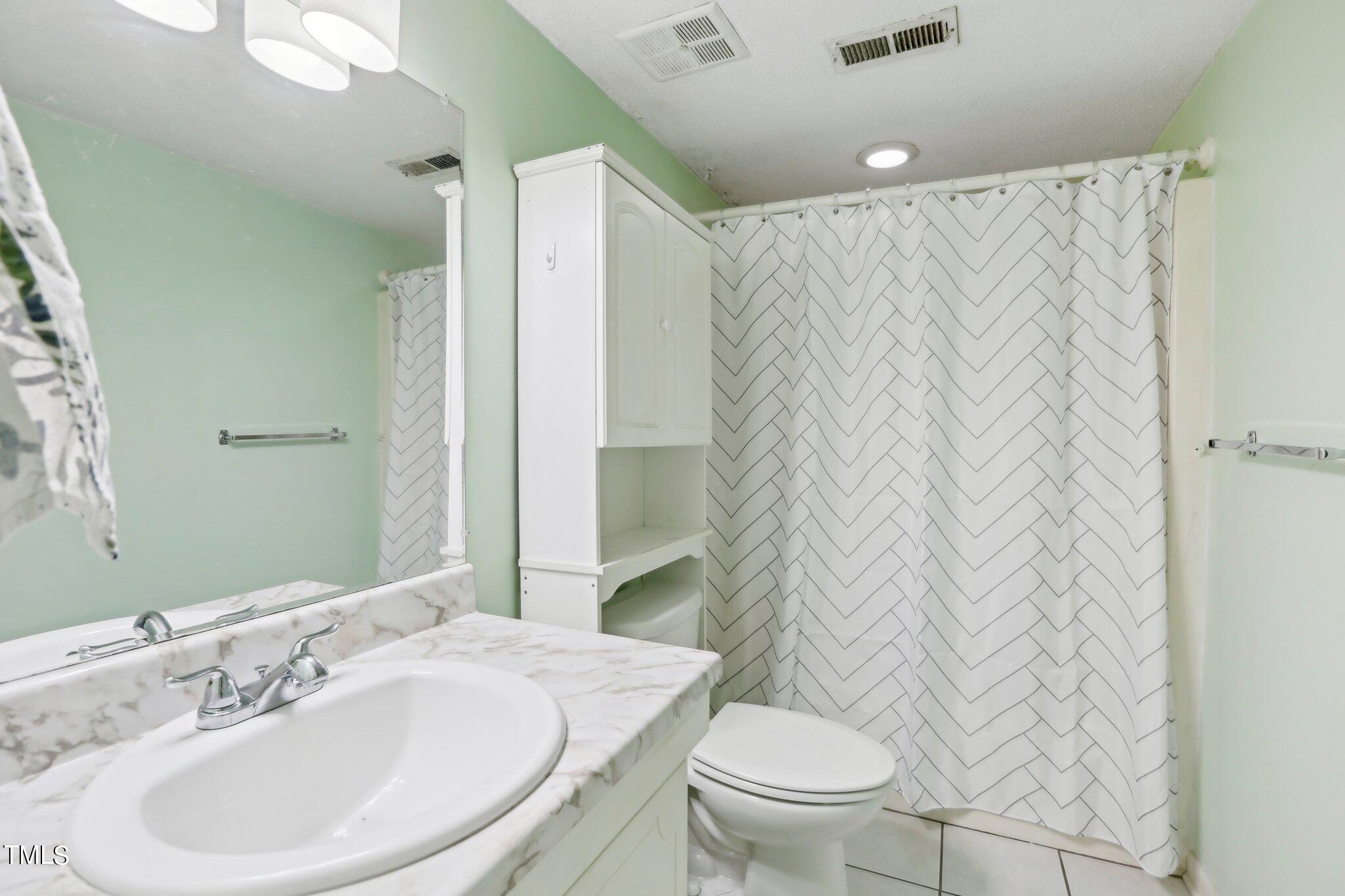 1216 Manassas Court, Unit E Raleigh, NC 27609 - Photo 11 of 20 a bathroom with a sink toilet and shower