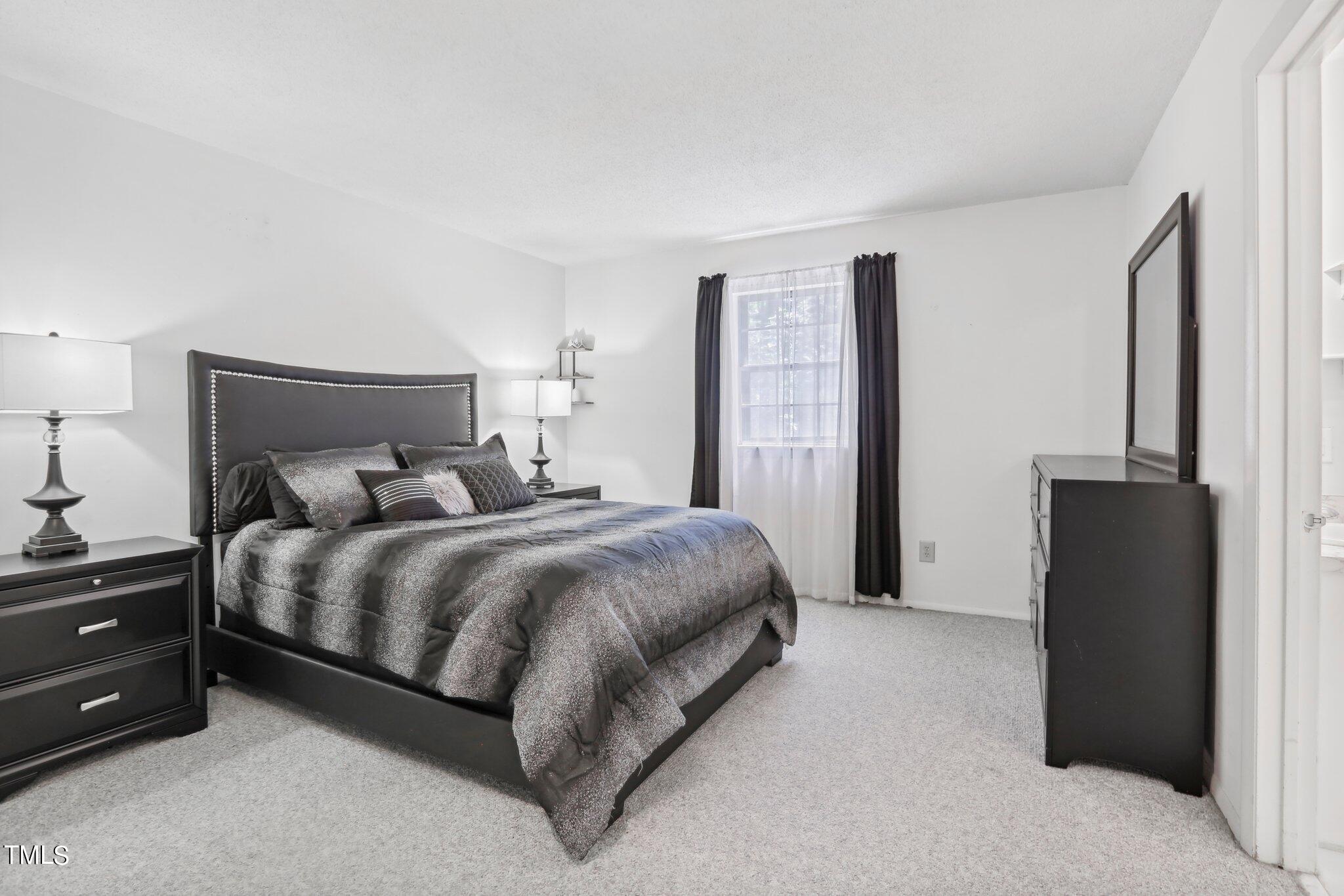 1216 Manassas Court, Unit E Raleigh, NC 27609 - Photo 14 of 20 a spacious bedroom with a bed and a dresser