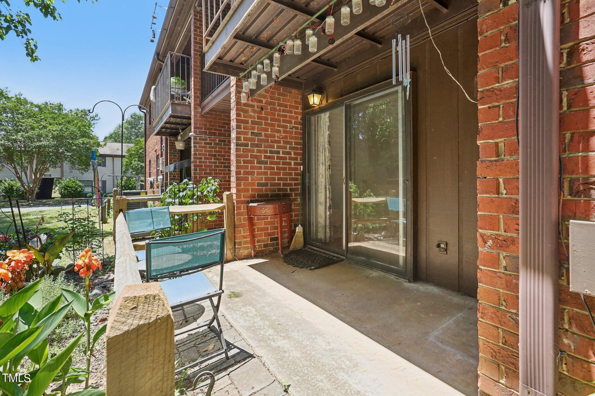 1216 Manassas Court, Unit E Raleigh, NC 27609 - Photo 19 of 20 a view of backyard with a table and chair and potted plants
