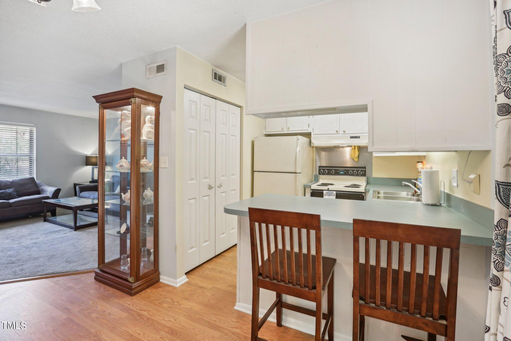 1216 Manassas Court, Unit E Raleigh, NC 27609 - Photo 7 of 20 a kitchen with stainless steel appliances a refrigerator and wooden floor