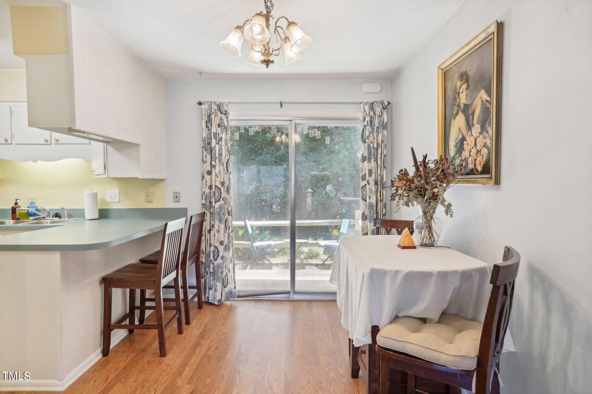 1216 Manassas Court, Unit E Raleigh, NC 27609 - Photo 9 of 20 a view of a dining room with furniture window and wooden floor