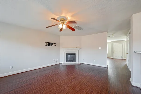 a view of empty room with wooden floor and fireplace