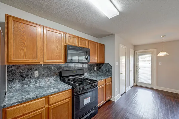 a kitchen with stainless steel appliances granite countertop wooden cabinets and a stove top oven