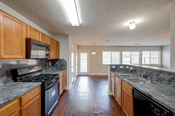 a kitchen with stainless steel appliances granite countertop a sink stove and cabinets