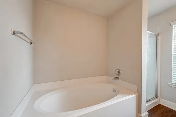 a white bath tub sitting next to a shower