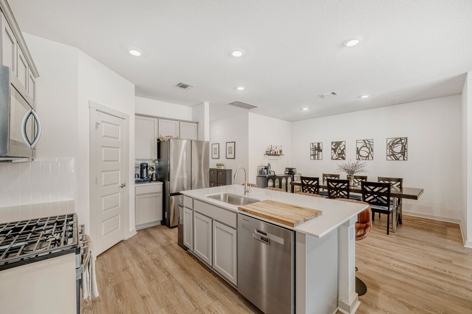 2308 Ranier Court Austin, TX 78754 - Photo 13 of 29 Kitchen with a center island with sink, stainless steel appliances, light wood-style flooring, recessed lighting, and a kitchen bar