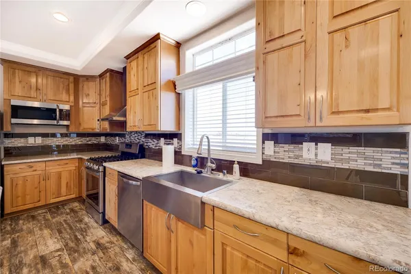 a kitchen with stainless steel appliances granite countertop a sink and a stove